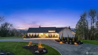 Professionally landscaped with ambient exterior lighting.