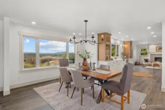 Elegant main floor dining room with timeless iron chandelier and recessed lighting.