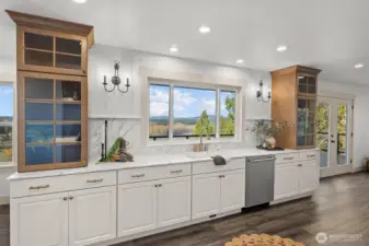 Kitchen with custom cabinetry with soft close and pull-out drawers, marble countertops and backsplash, Kohler enameled cast iron sink and upgraded Delta bridge faucet.