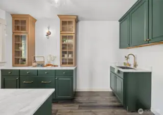 Butler's pantry off hearth room with custom cabinetry, marble countertops and Thermador stainless steel beverage refrigerator. Perfect for entertaining! Also serves as main floor laundry room with utility sink too!