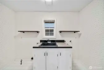 Oversized laundry room with sink is upstairs off the kitchen. Plumbed to add a toilet if you wanted an additional half bath.