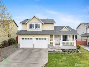 This charming two-story home features a welcoming covered front porch, classic curb appeal, and a spacious two-car garage in a desirable neighborhood setting.