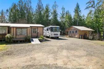 Front of home with gravel driveway and plenty of parking for RVs and vehicles.