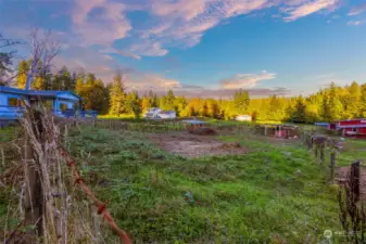 Two fenced paddocks with shelters are between the house and the barn