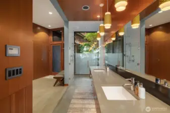 Floating vanity, walk-in glass shower, and integrated laundry.