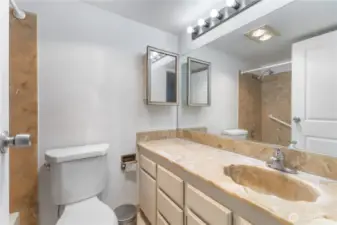 Primary 3 piece bathroom with large mirror stone counters and updated lighting