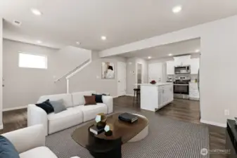 Open sightlines from living area to kitchen keep everyone connected, with durable plank flooring underfoot. Pictures are for representational purposes only, colors and features may vary.
