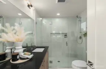 With glass shower, designer tile, and modern lighting, this bathroom turns everyday routines into moments of luxury. Photos are of model home with similar fixtures & finishes.