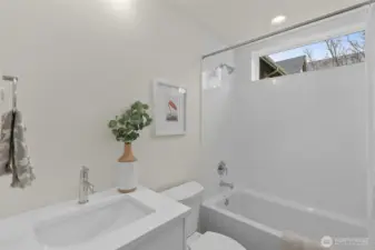 A bright bathroom retreat designed with stylish tilework and natural tones, balancing beauty with practicality. Photos are of model home with similar fixtures & finishes.