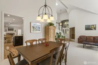 The open and spacious formal living and dining rooms boast tall vaulted ceilings and wainscoted walls.