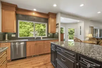 The informal areas are one contiguous space and feature an updated kitchen with maple cabinets with soft close drawers and doors, slab granite counters, an island with seating, stainless steel appliances including a gas range and a walk-in pantry.