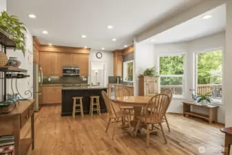 The informal areas are one contiguous space and feature an updated kitchen with maple cabinets with soft close drawers and doors, slab granite counters, an island with seating, stainless steel appliances including a gas range and a walk-in pantry.