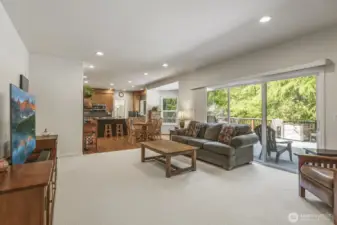 The informal gathering room features a stone surround gas fireplace and sliding door to the deck.