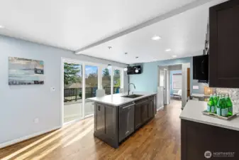 The center island, with seating for 4 or more, holds the sink and dishwasher. Sliders to the deck increase the living area in nice weather.