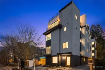 An evening masterpiece awaits you at The Veridian in Crown Hill. This stunning facade showcases modern architecture illuminated beautifully by twilight, hinting at the luxurious lifestyle.