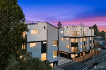 A stunning exterior view of modern multi-story homes against a vibrant dusk sky.