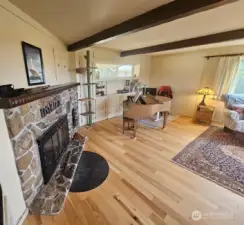 Huge fireplace with original cupboards for wood storage and the beams in the ceiling highlight this expansive living/dining room with the amazing view out to the ocean!