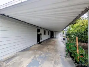 Long driveway. EV charger to the right of the carport entry door.
