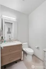 Style and utility for everyday living.  The powder room is fresh, bright, and effortlessly modern. Ideal for guests or quick use throughout the day, it reflects the same elevated design found throughout the home, with soft-close cabinetry, updated fixtures, and durable tile underfoot.