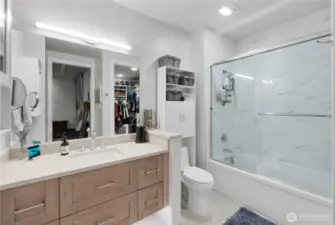 Where form meets function.  This full bathroom blends modern elegance with practical comfort. A quartz-topped vanity with soft-close drawers offers ample storage, while the oversized mirror and sleek lighting make the space feel bright and open. The layout smartly connects directly to the walk-in closet, creating a private dressing suite feel. Everything you need, right where you want it.