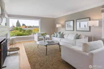 The charming wood-burning fireplace with classic 1940’s detailing, including a crisp painted mantel, fluted millwork, and timeless crown moldings—anchor the living room with warmth and character.