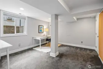 Bedroom number four, currently staged as an office, offers flexibility for work-from-home, guest use, or creative space—brightened by a large window for natural light and proper egress.