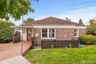 Private backyard retreat with spacious entertaining deck, string lighting, and level lawn—perfect for outdoor dining, play, and gatherings.