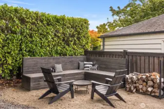 Cozy outdoor fire pit area with built-in seating and wood storage—perfect for making memories with loved ones and friends.