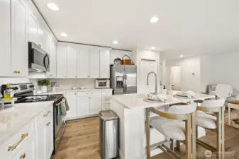 A stunning custom kitchen complete with quartz countertops and designer tile backsplash.
