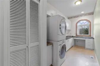 Laundry room with washer/dryer, cabinetry, and office nook.