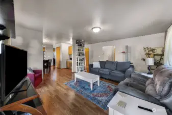 The view from the family room showcases the open layout leading to the dining room, to the laundry room, and the three car garage.