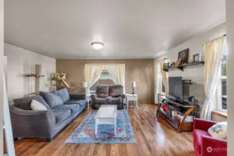 The family room features, large windows, a continuation of beautiful flooring, and a spacious layout.