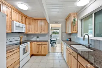 Cook with nature as your backdrop—this warm, well-appointed kitchen pairs natural wood cabinetry with peaceful lake views, offering everyday function and timeless charm. For those dreaming of an open-concept flow, the owners once considered removing the dividing wall to create a more connected space between the kitchen and main living area—an opportunity still full of potential.