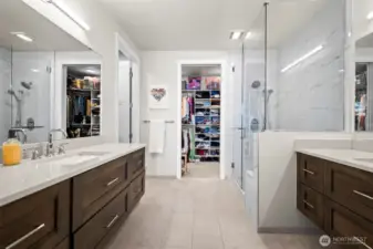 Spa-inspired bath featuring double vanities and heated tile flooring