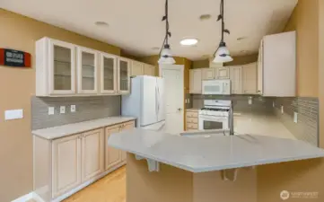 The kitchen features a sit-here bar, tons of custom cabinetry, and a pantry.