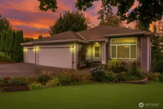 Elegant twilight shot featuring warm exterior glow and evening sky views.