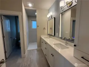 Primary Bathroom with tile shower, separate commode room, double sinks, granite counters, dual lighted and fog control mirrors