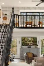 The staircase leads to a loft with floor-to-ceiling shelving.