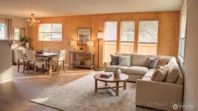 Bright and comfortable, the living room offers an open, airy feel with warm wood accents, generous natural light, and an easy flow into the dining area for relaxed everyday living.