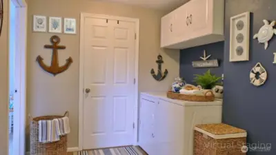 Laundry area off the living room with a bathroom and bedrooms nearby, plus a door that allows this wing of the home to be closed off from the main living space.