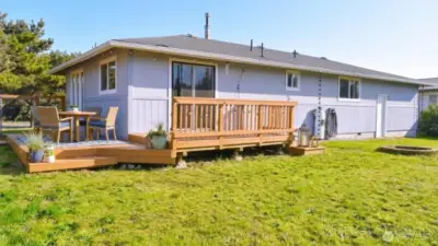 Spacious backyard with a wide lawn and a sunny deck that’s perfect for outdoor dining and casual gatherings.