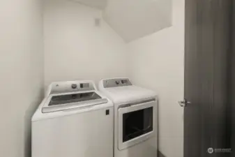 Laundry room is conveniently located in the upper level landing between all bedrooms and features a newer GE top-loading washer and dryer.