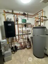 The utility room on the lower level houses the tankless hot water unit plus the additional hot water tank - all are needed for the radiant heating system and daily use.