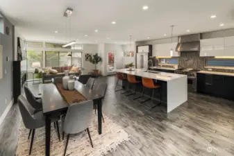 This view shows how connected the home is, while still creating separate areas for cooking, eating and relaxing. Perfect space for those who love to entertain! Beautiful radiant heated engineered hardwood floors flow throughout the home.