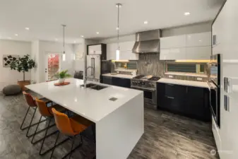 The chef's kitchen features a large, sleek island that serves as the focal point, perfect for both meal prep and casual dining. Its open concept design seamlessly blends into the living area, creating an inviting space for gatherings.