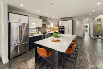 Garage door-style upper cabinets, pot filler, designer backsplash with large windows, spacious pantry cabinets, pullout spice cabinet, and hidden silverware drawers are just some of the extra touches you'll find in this dream kitchen!
