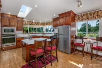 The island kitchen with Cherry cabinets has views of the lake.