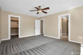 Another view of primary looking into walk-in closet and primary bathroom.