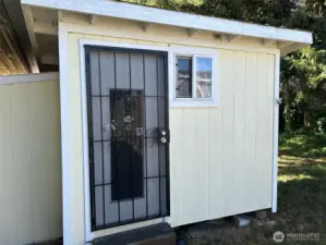 Secure storage shed behind carport
