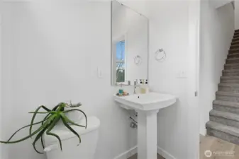 Stairs opposite half bath lead up to third floor